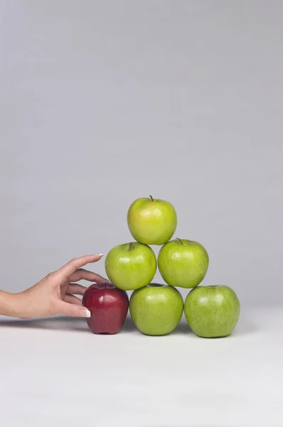 Hand ta apple från stacken av äpplen Royaltyfria Stockfoton