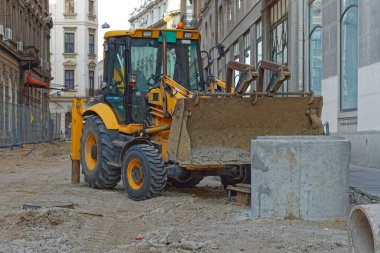 Şehir kanalizasyonunda kepçe kazıcı yükleyici makinesi