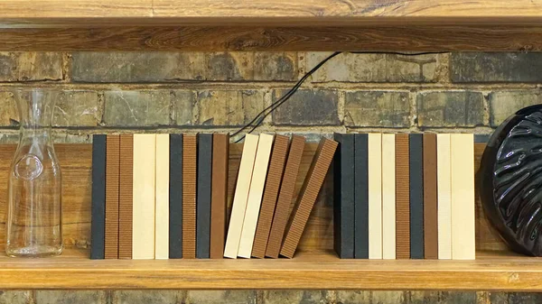 Collection of books at wooden wall shelf rack home library
