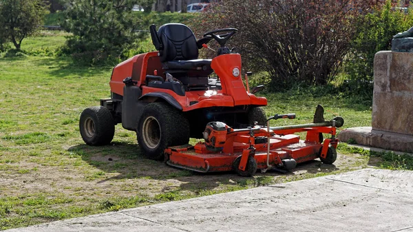 Powerful riding lawn mower machine in city park