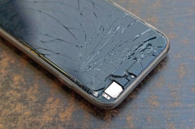 Broken screen display glass smartphone mobile phone at desk