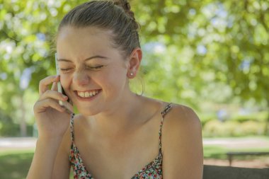 gülümseyen genç kızın cep telefonundan arıyor