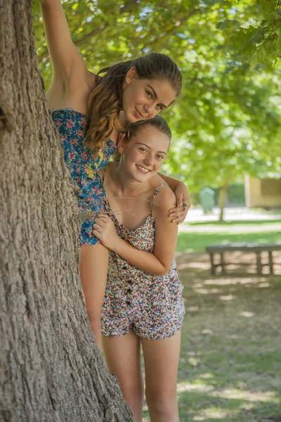 Two girls hugging each other in forest — Stock Photo, Image