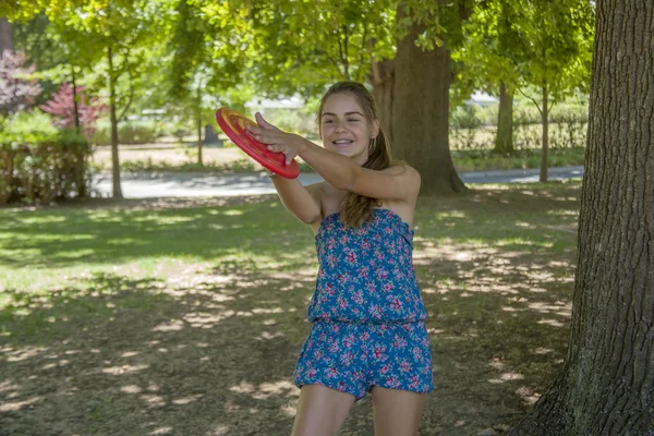 Mujer joven al aire libre lanzando un frisbee — Foto de Stock