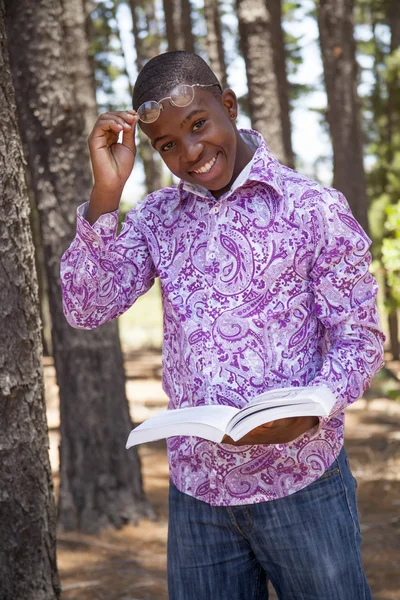 African teenager boy reading a book outdoors — Stock Photo, Image