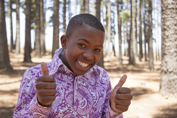 Afrikansk pojke ser till kameran och ler — Stockfoto