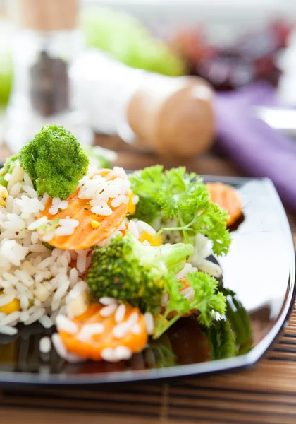 Rice with vegetables on black dish — Stock Photo, Image