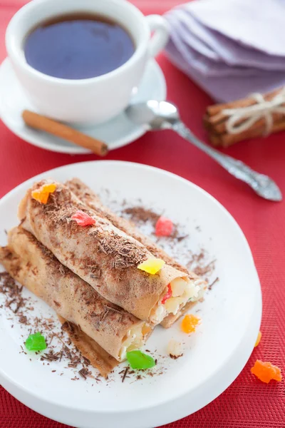 Pancakes rolled in a tube and a cup of tea — Stock Photo, Image