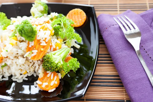 Gekookte rijst met groenten in zwarte schotel mix — Stockfoto