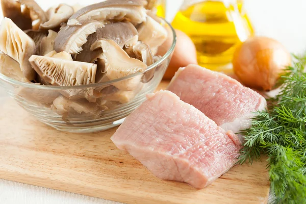 Сырое мясо и грибы на доске, и другие ингредиенты — стоковое фото