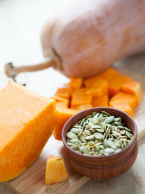 Bütün Balkabağı tohumları bir kase ve kabak parçaları