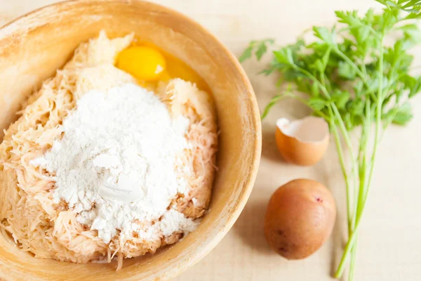 Тертый сырой картофель, яйца и мука в большой миске — стоковое фото
