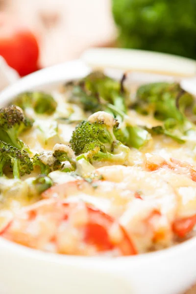 Broccoli under cheese baked with tomatoes — Stock Photo, Image