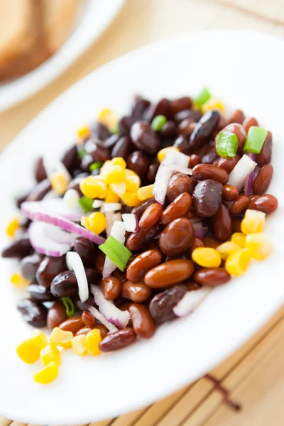 Several kinds of beans on a white plate — Stock Photo, Image
