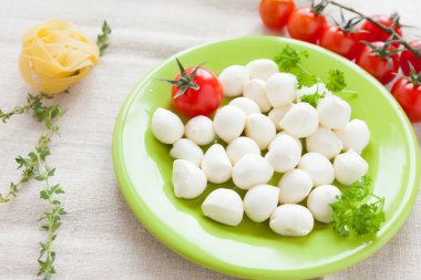 yeşil bir tabak üzerinde mozzarella peynir topları