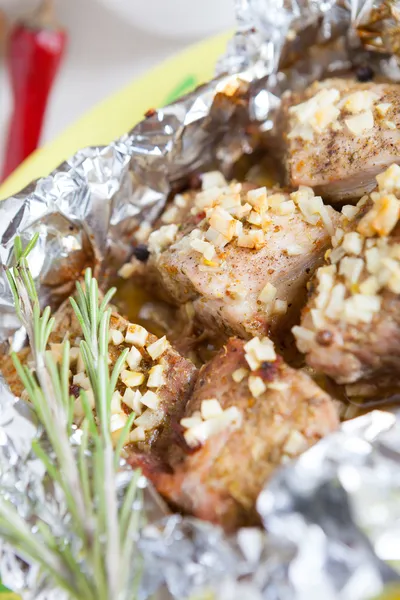 Pieces of meat baked in foil in the oven — Stock Photo, Image