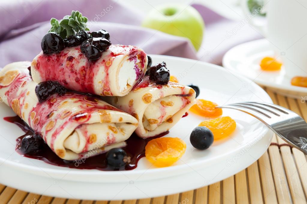 pancakes with cottage cheese in the middle and berry sauce