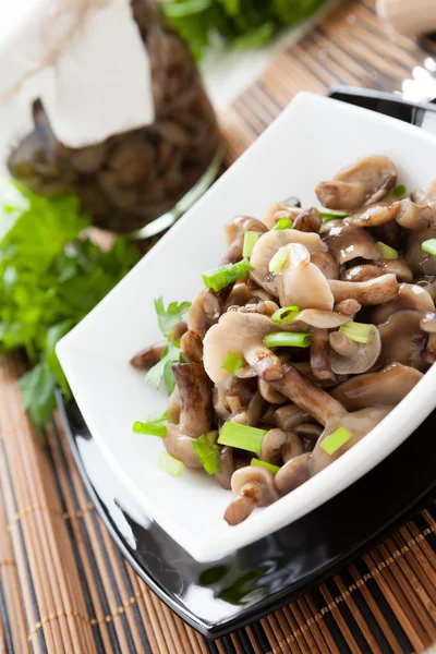 Marinated mushrooms and green onions in a white bowl and a glass — Stock Photo, Image