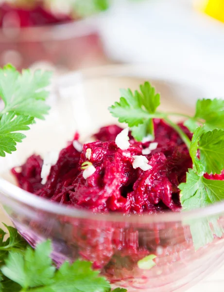 Grated beetroots and garlic in a transparent bowl — Stock Photo, Image