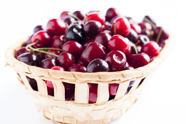 Cerezas en canasta de mimbre. Bayas maduras . — Foto de Stock