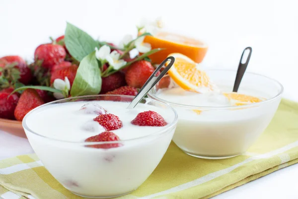 Färsk yoghurt och en platta av mogna jordgubbar — Stockfoto