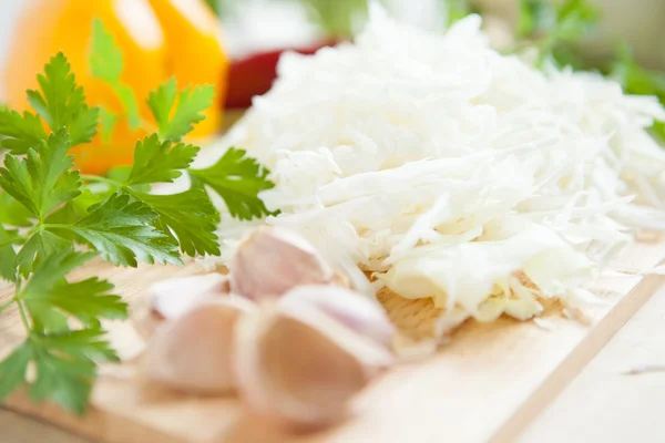 Raw cabbage cut into thin slices and garlic closeup — Stock Photo, Image