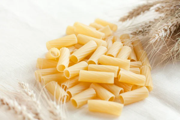 Maccheroni e spighe di grano su tela — Foto Stock