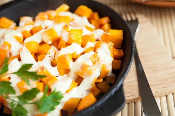 Delicious pieces of pumpkin with cream sauce — Stock Photo, Image