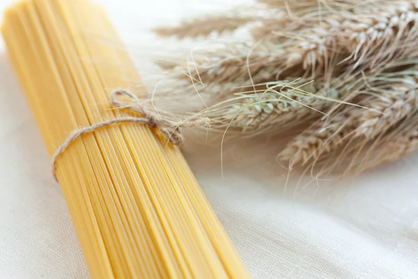 Spaghetti crudi e spighe di grano maturo — Foto Stock