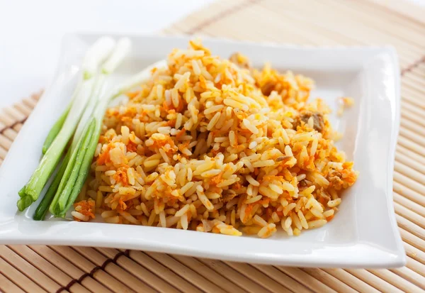 Рис с зеленым луком и коричневым хлебом на белой квадратной тарелке — стоковое фото