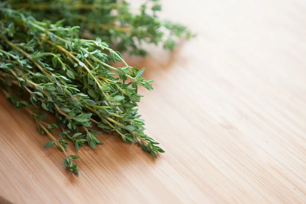 Bunch of green thyme on a wooden surface — Stock Photo, Image