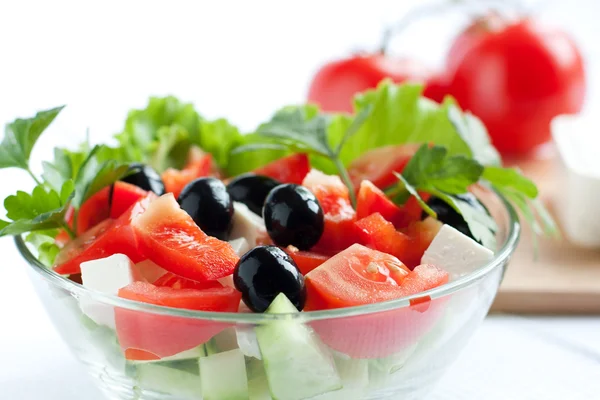 Griekse salade op een achtergrond ingrediënten — Stockfoto