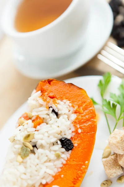 Baked pumpkin with rice and raisins and cup of tea — Stock Photo, Image