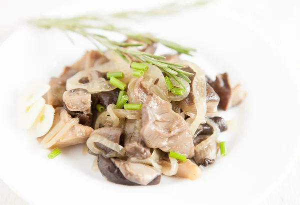 Oyster mushrooms and onions on a white dish — Stock Photo, Image