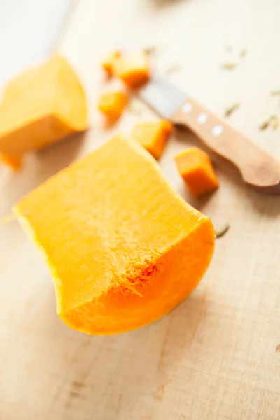 Half a pumpkin and a knife on a wooden surface — Stock Photo, Image