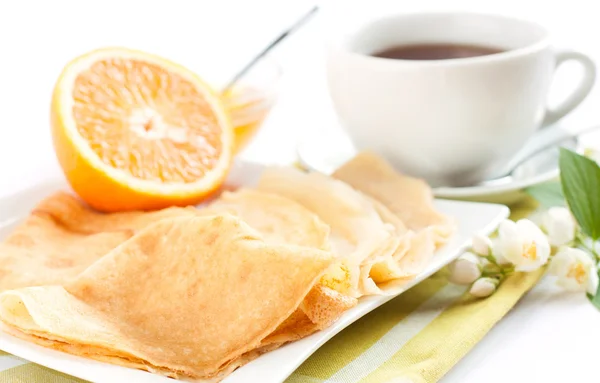 Pancakes topped with orange juice and tea — Stock Photo, Image