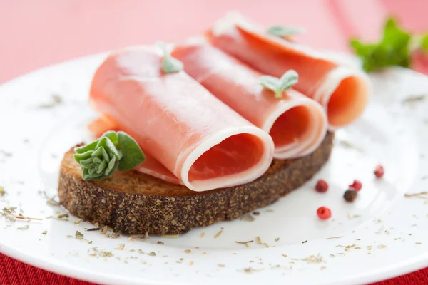 Spanish jamon slices on white dish — Stock Photo, Image
