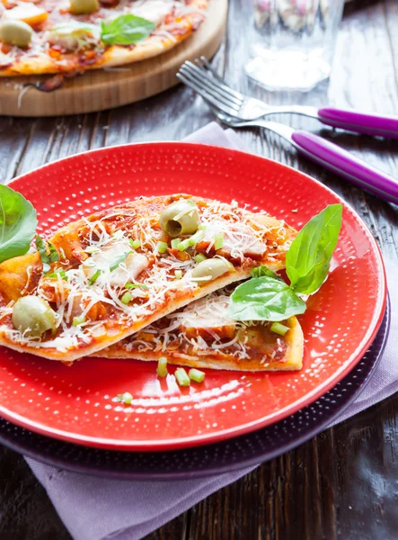 Dunne plakjes van smaakvolle pizza op een plaat — Stockfoto