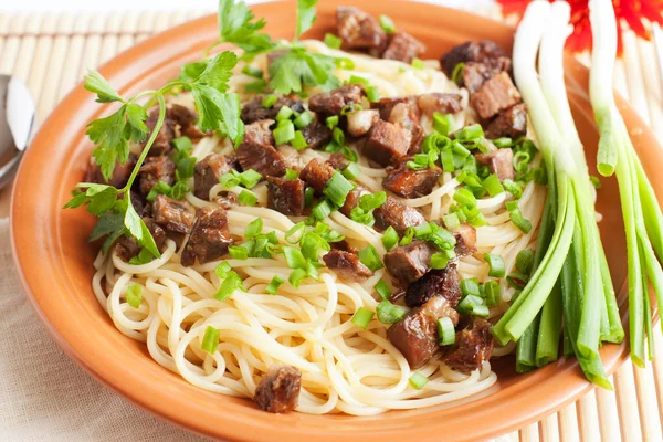 Delicious spaghetti with fried meat and green onions — Stock Photo, Image