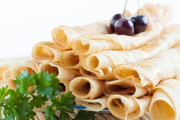 Thin pancakes rolled into a tube on a plate — Stock Photo, Image