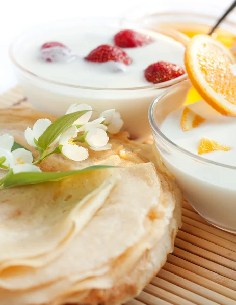 Panquecas douradas e dois iogurtes de frutas — Fotografia de Stock