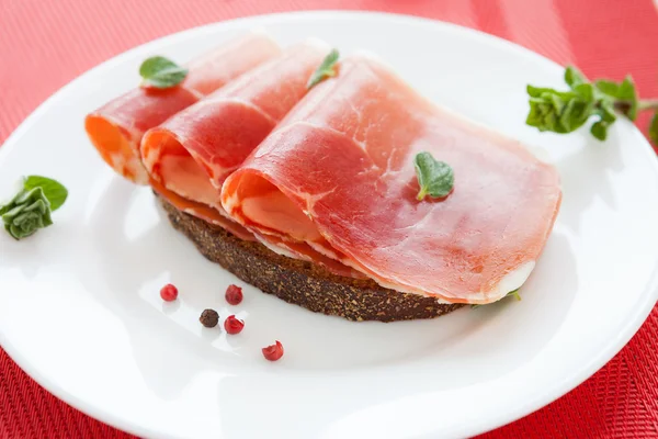 Segmenten van smakelijk ham en maïs brood — Stockfoto