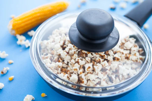 Delicious homemade popcorn in a pan under the transparent cover — Stock Photo, Image