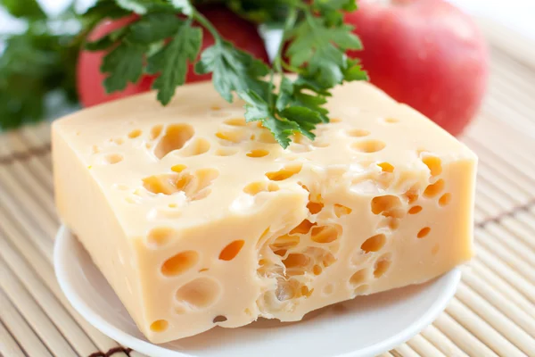 Morceau de fromage sur fond de tomate — Photo