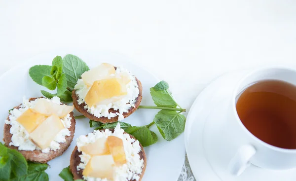 Kekse mit Weichkäse und Birne, dazu eine Tasse Tee — Stockfoto