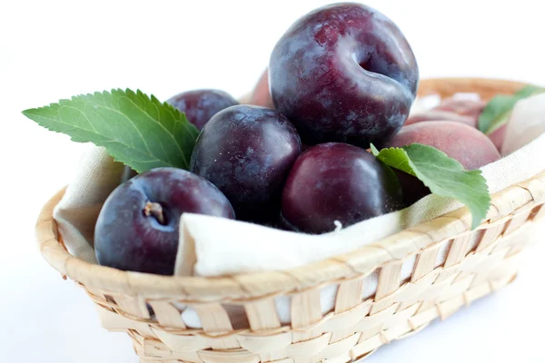 Plums in wooden basket — Stock Photo, Image