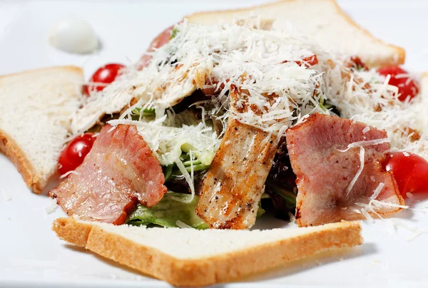 Salad greens with bacon, parmesan cheese, bread — Stock Photo, Image