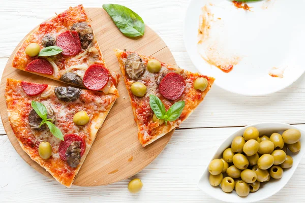 Segmenten van pizza en een lege schotel — Stockfoto