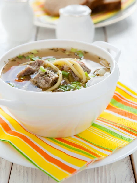 Voedzaam vlees soep met pasta in een witte terrine — Stockfoto