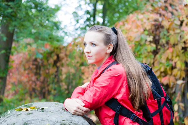 Portrait of a beautiful girl with a backpack near the stone — Stock Photo, Image